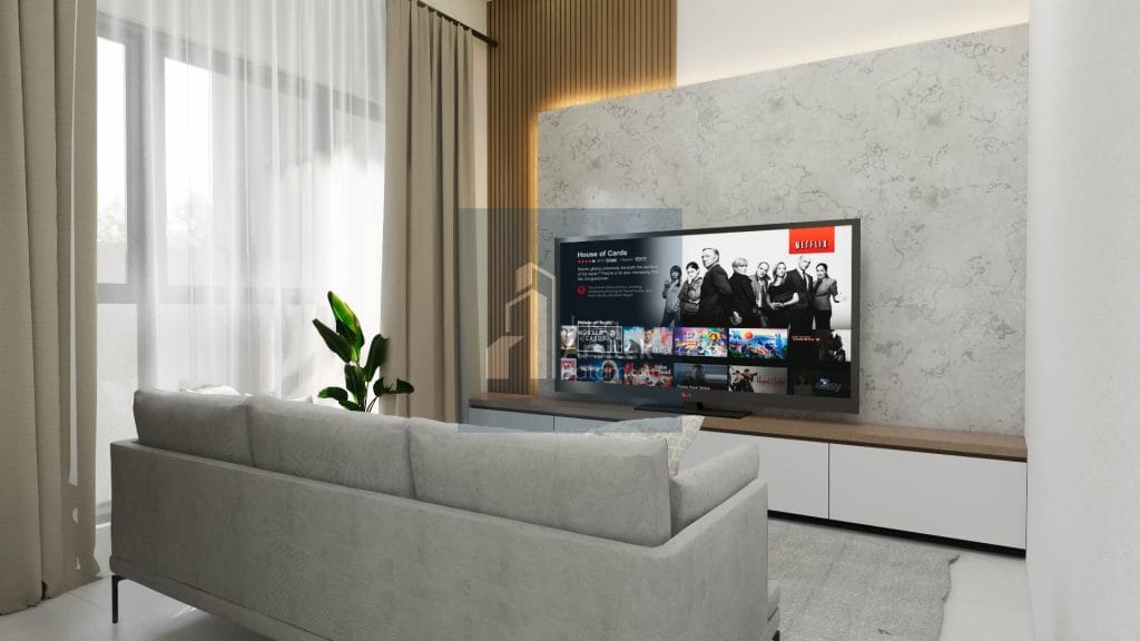 Desain ruang tamu modern dengan sofa abu-abu, TV besar di dinding marmer, dan tanaman hijau yang menambah suasana segar.